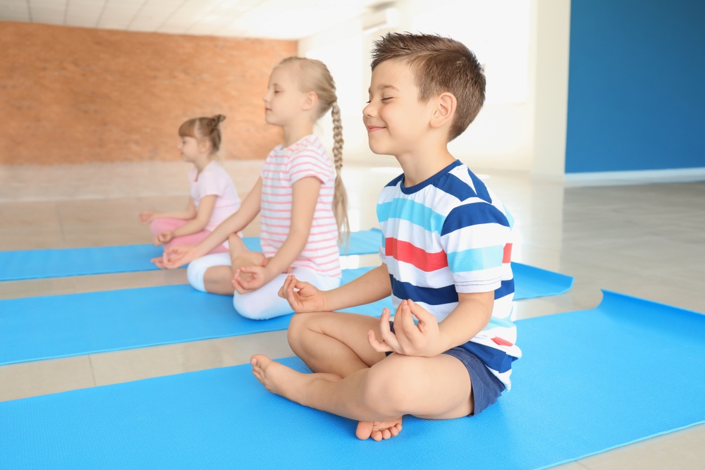 An image of children doing some meditation, Little Sunshine provide children with emotional development in the classroom.